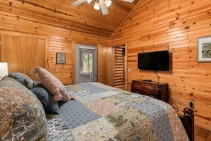 A wooden cabin bedroom with a bed, a television, and a dresser. - Quiet Cabin1 mile to SDC - 4 Private Bed/Bath Masters, 2 Living Areas, 2 Pools! | 35 (Branson West)