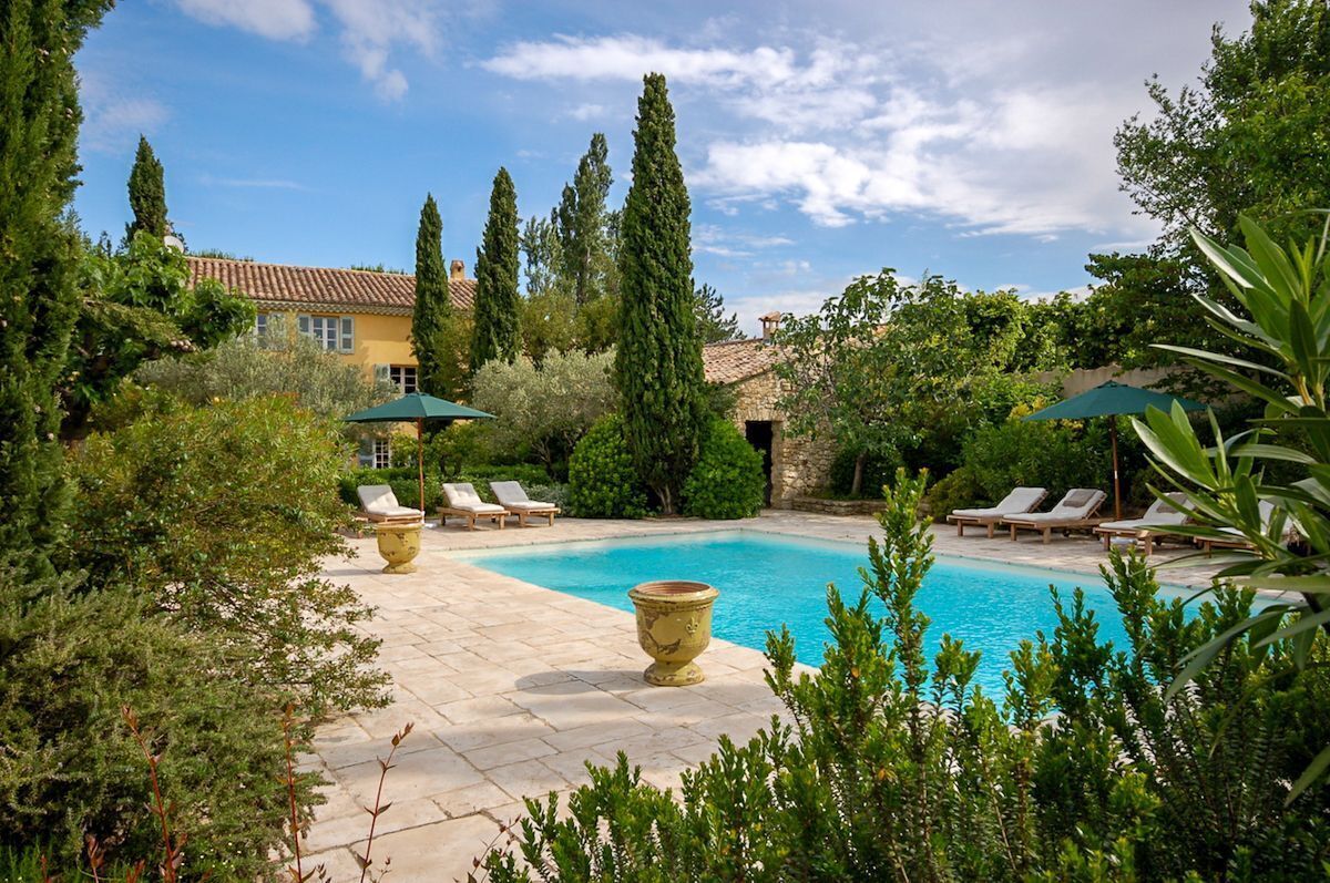 A pool area with lounge chairs and a stone pathway.