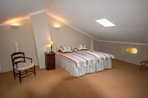 A bedroom with a bed, a chair, a nightstand, and a wall-mounted lamp. - Maison Cerisaie - Four Bedroom Villa, Sleeps 8 (Pernes-les-Fontaines)