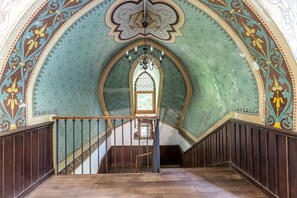 A grand staircase with a decorative ceiling and a stained glass window. - Chateau Des Pyrenees (Bagnères-de-Luchon)