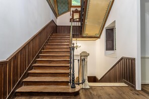 A wooden staircase with a handrail and a chandelier. - Chateau des Pyrenees (Bagnères-de-Luchon)