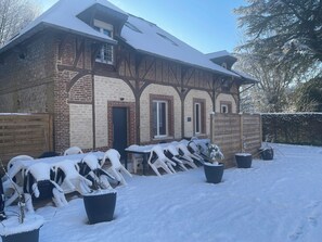 A brick building with a snow-covered roof and a wooden fence.