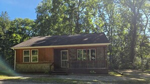 A small cabin with a porch, surrounded by trees. - Lakefront views of Willscreek Lake 2 bedroom (Adamsville)