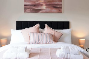 A neatly made bed with white linens, two pillows, and a striped pillow. - Forthside House - 3 Bedroom House, Kincardine (Kincardine)