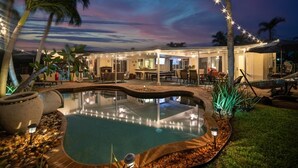 A pool area with a hot tub, outdoor seating, and string lights. - Vibrant Haven: Private Dock • Games • Patio (Oakland Park)