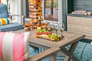 A wooden table with a charcuterie board, wine glasses, and a stack of wooden blocks. - Vibrant Haven: Private Dock • Games • Patio (Oakland Park)
