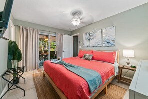 A bedroom with a bed, a nightstand, a lamp, a clock, and a view of an outdoor area with a table and chairs. - Vibrant Haven: Private Dock • Games • Patio (Oakland Park)
