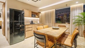 Una cocina moderna con refrigerador integrado, armarios de madera y un comedor con mesa y sillas.