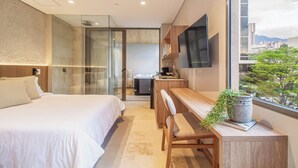 Una habitación de hotel moderna con cama, escritorio y televisión.