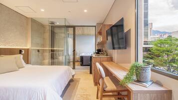 Una habitación de hotel moderna con cama, escritorio y televisión.
