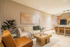 Una sala moderna con un sofá, una mesa de centro y un comedor con sillas.