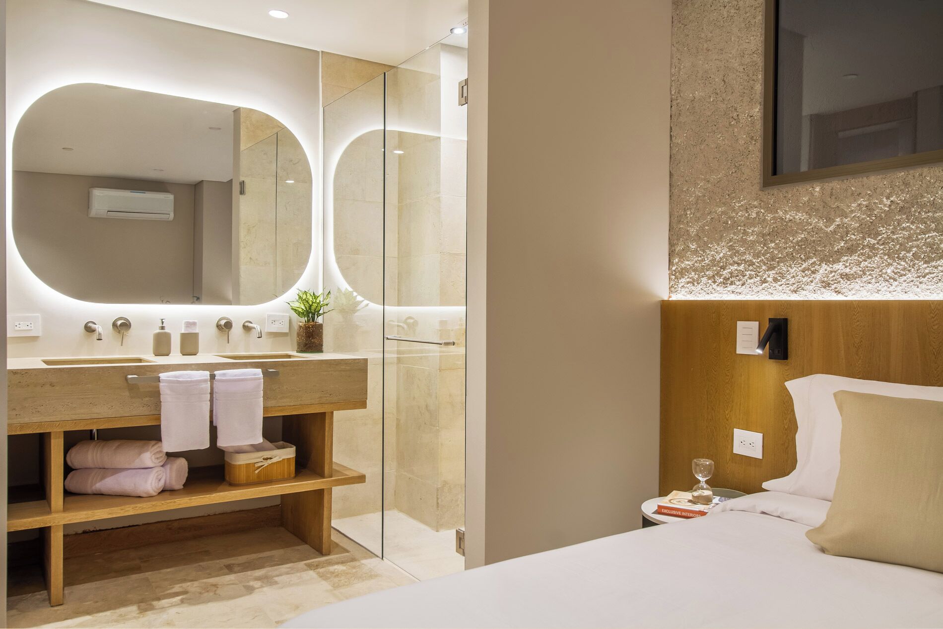 Un baño moderno con un espejo grande, un mueble de tocador de madera y una cama con cabecera de madera.