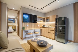 Un espacio habitable compacto con kitchenette, zona de comedor y área de descanso.