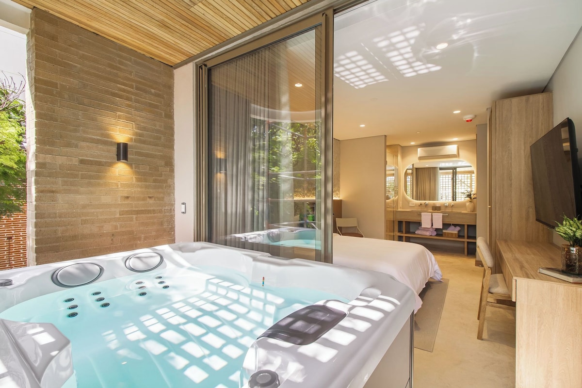 A modern bathroom with a large bathtub, a shower area, and a vanity with a mirror.
