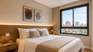 Ein Hotelzimmer mit einem großen Bett, einem Nachttisch mit Lampe, einer kleinen Pflanze und einem Fenster mit Blick auf die Stadt.