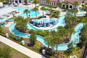 A pool area with multiple swimming lanes, lounge chairs, and palm trees. - Go!#42 - WINDSOR AT WESTSIDE (Kissimmee)