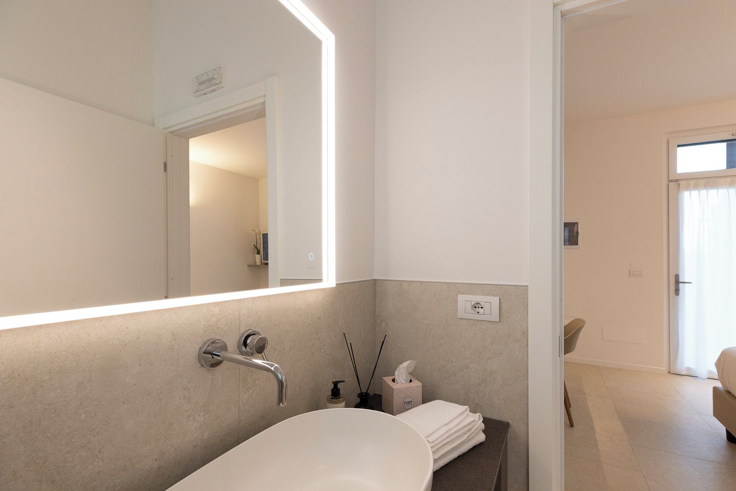 Ein modernes Badezimmer mit einer Badewanne, einem großen Spiegel und einem Handtuchhalter.