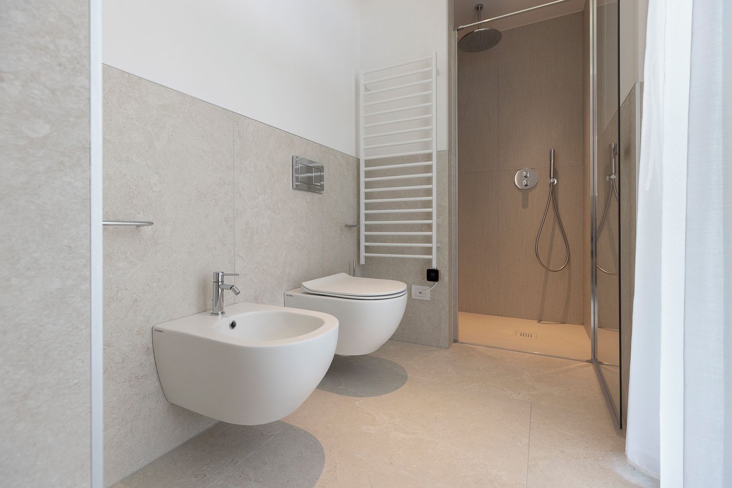 Un baño moderno con bidé, inodoro y ducha.