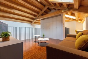 Un interno moderno con soffitto in legno, un divano, un tavolino e una pianta in vaso.