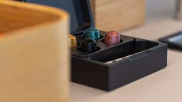 A black tray with three metallic objects, possibly a set of keys or tools, on a wooden surface.