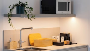 A modern kitchen with a stainless steel sink, a microwave, and a coffee machine. - Grow Green (Caponago)