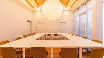 A conference room with a long table, chairs, and a large circular light fixture on the ceiling.