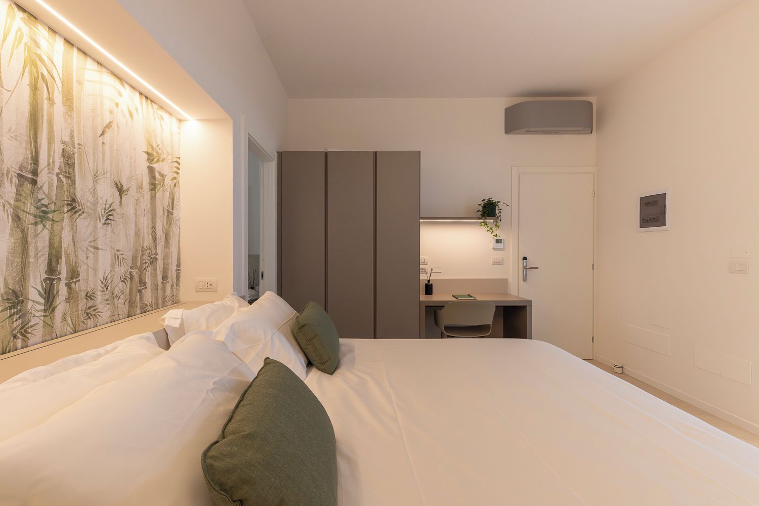 Une chambre à coucher avec un lit, un bureau et une armoire.