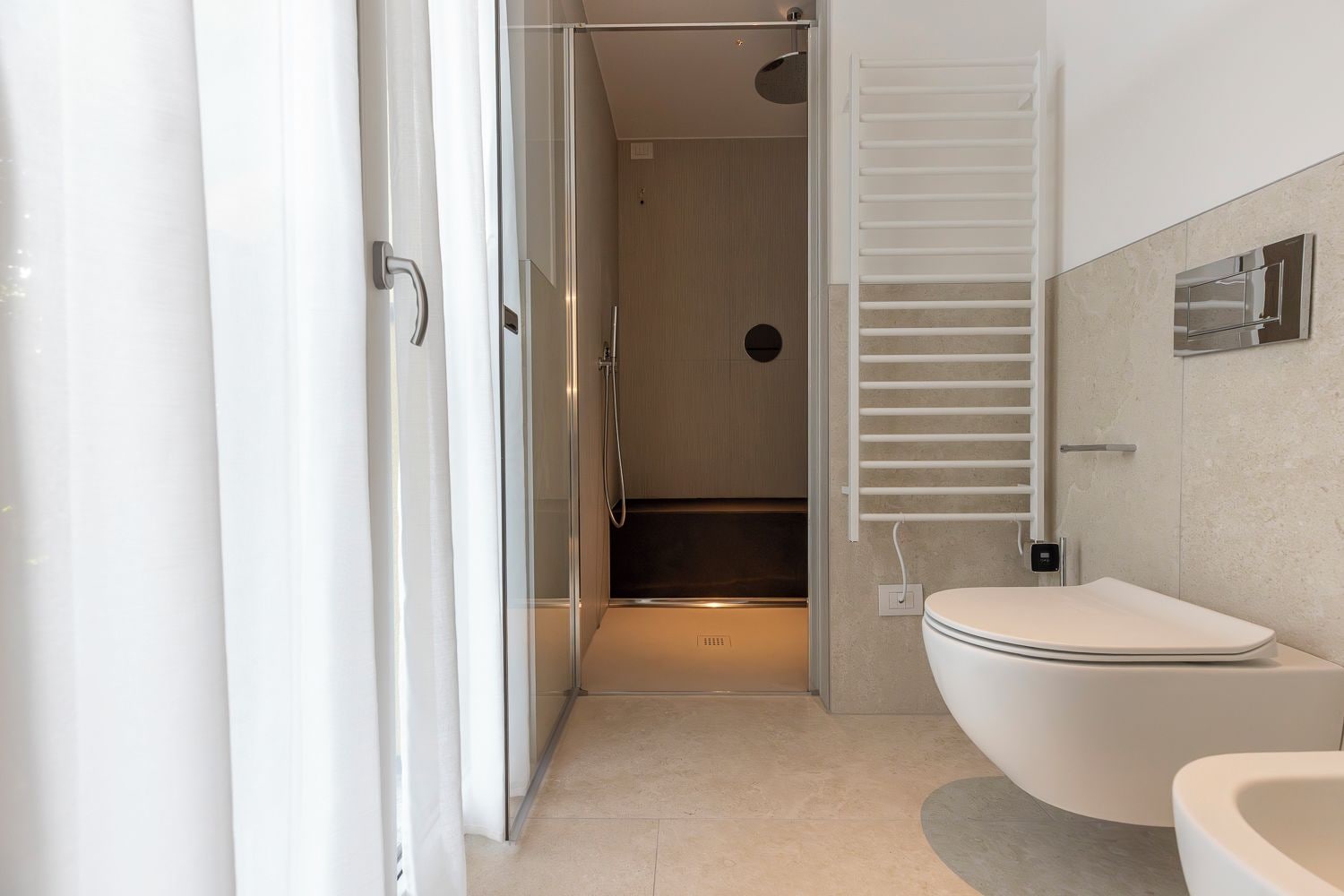 Un bagno moderno con doccia, toilette e porta asciugamani.