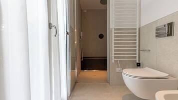 Un bagno moderno con doccia, toilette e porta asciugamani.