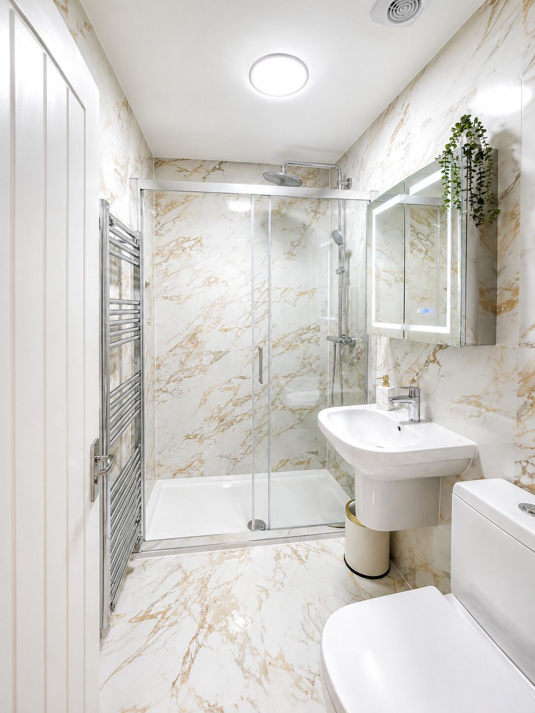 A modern bathroom with a glass-enclosed shower, a white sink, and a toilet.