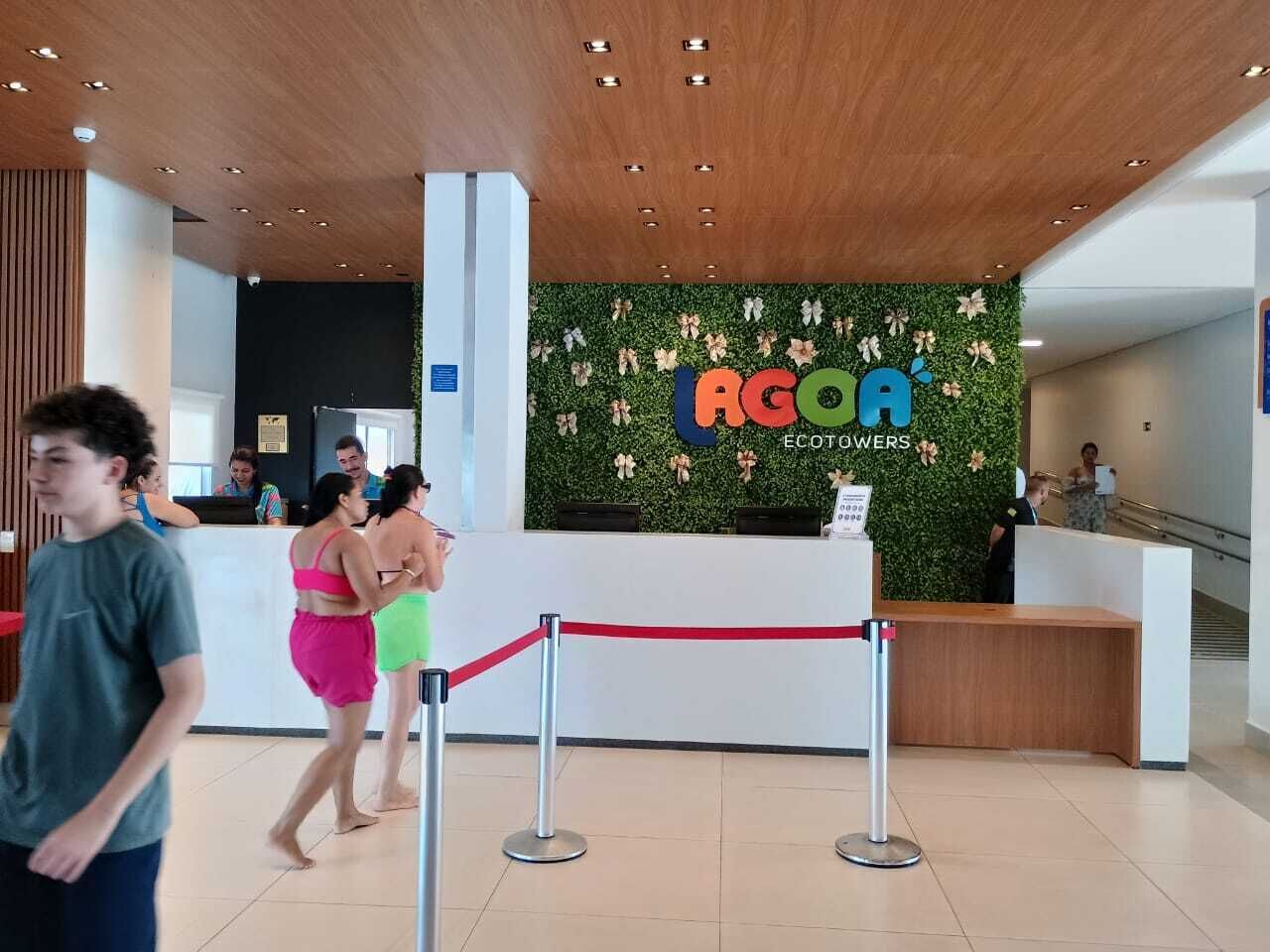 Een receptiegedeelte met een groene wand en een bord waarop 'AGOA ECOTOWERS' staat.