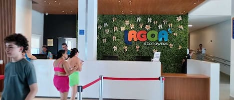 A reception area with a green wall and a sign that reads 'AGOA ECOTOWERS'.