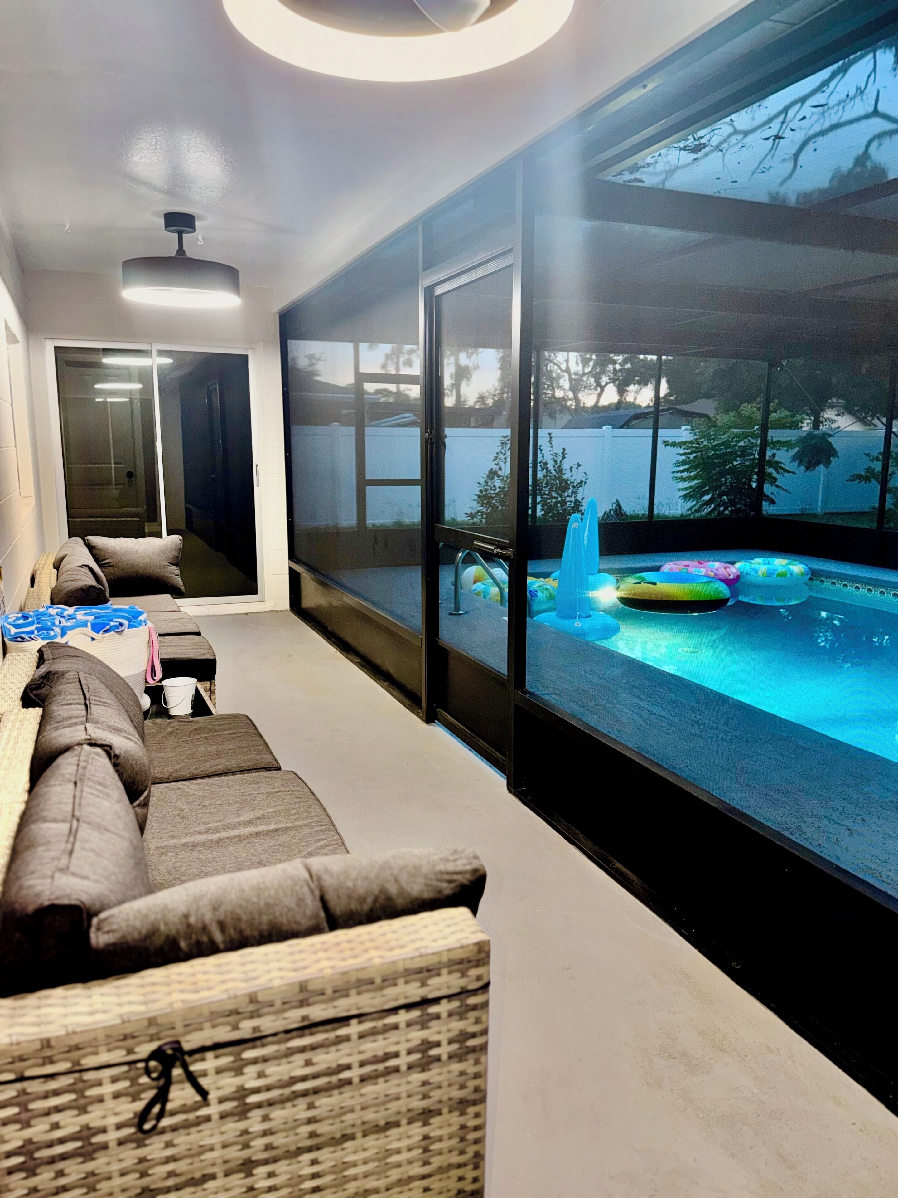 Una sala de estar moderna con un amplio ventanal que da a una zona con piscina.