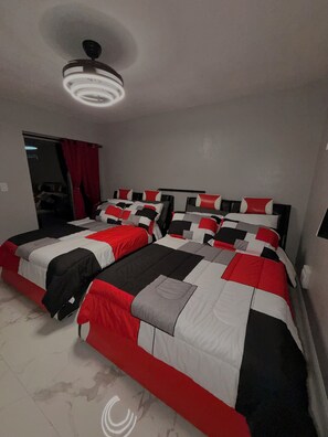 A bedroom with two beds, a ceiling fan, and a red curtain. - 4BR Home • Private Pool • Themed rooms • Sleeps 14 (Spring Hill)