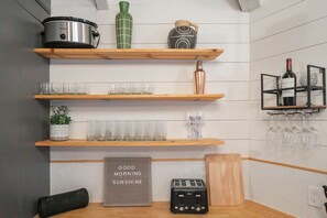 A kitchen with wooden shelves holding various items like a crockpot, a vase, and glasses. - Private 3-acre retreat with hot tub and fire pit (Rutherford County)