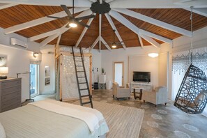 A spacious room with a high ceiling, a bed, a desk, a television, and a hanging chair. - Private 3-acre retreat with hot tub and fire pit (Rutherford County)