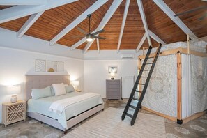 A bedroom with a sloped ceiling, a bed, a ladder, a dresser, and a wall-mounted air conditioner. - Private 3-acre retreat with hot tub and fire pit (Rutherford County)