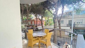Ein Balkon mit Korbmöbeln und Blick auf ein gegenüberliegendes Gebäude.