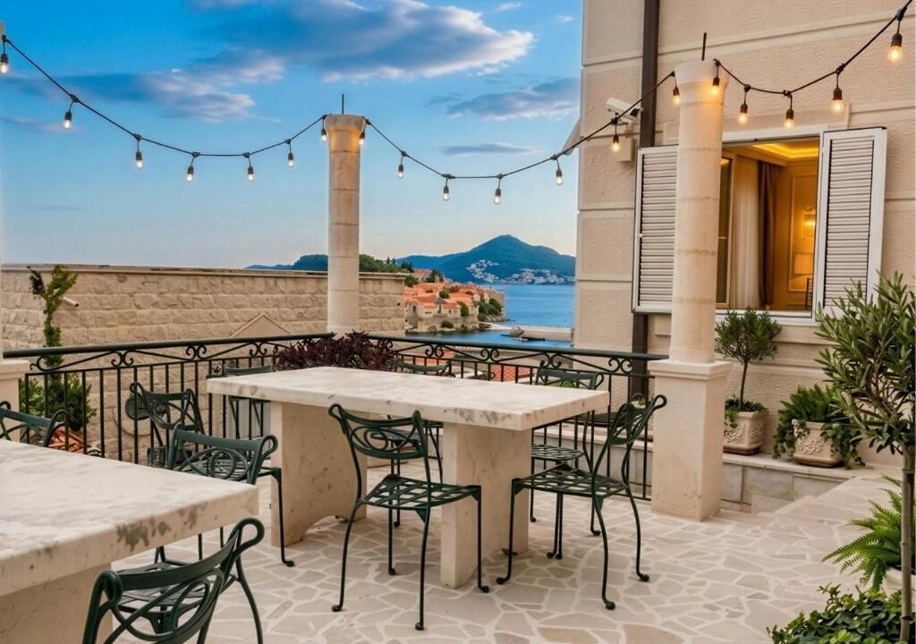An outdoor patio with a stone floor, green metal chairs, and a table.