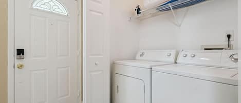 A laundry room with a door, a washing machine, and a dryer.