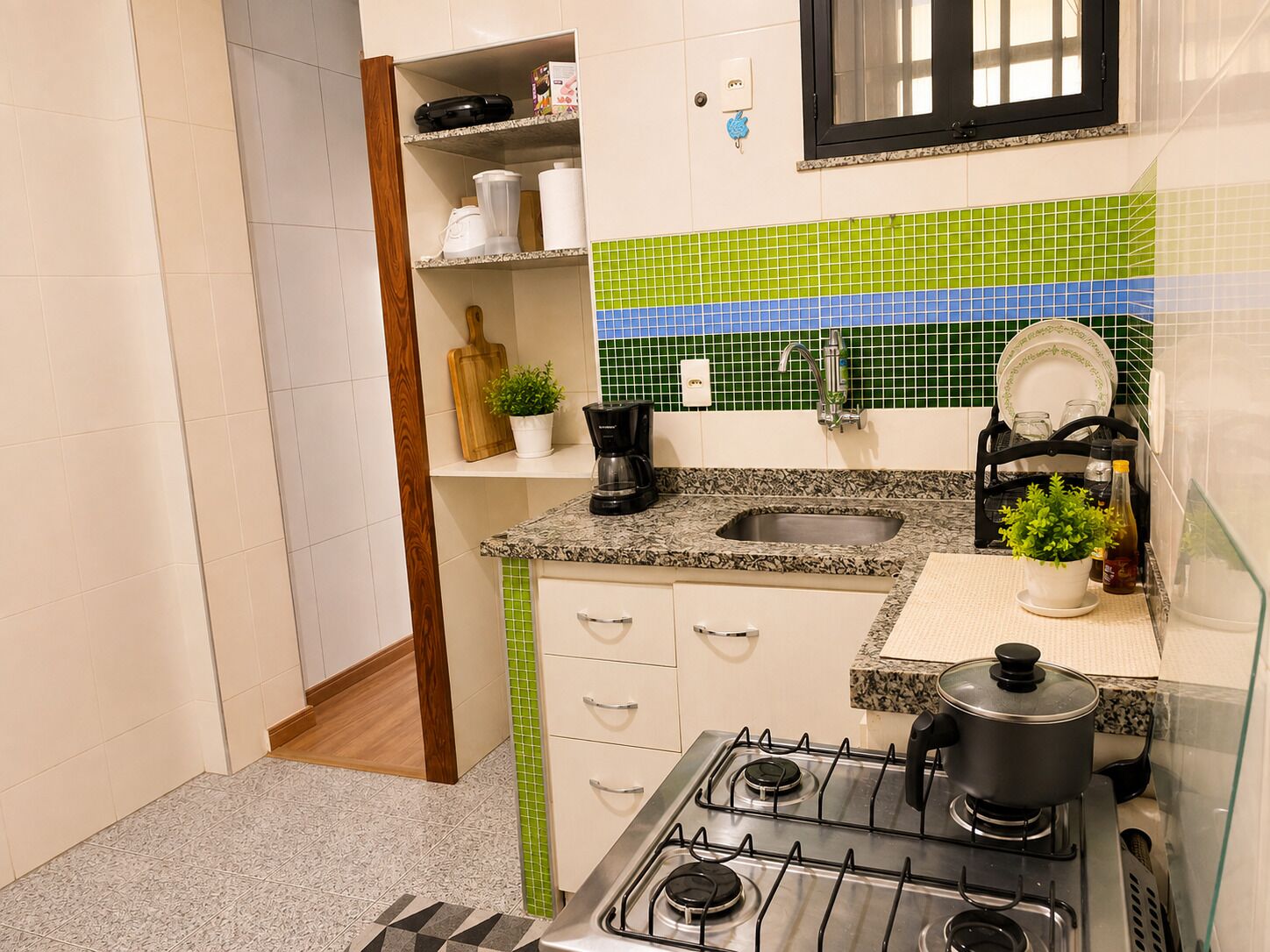 A compact kitchen with a gas stove, a sink, and a countertop.