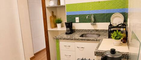 A compact kitchen with a gas stove, a sink, and a countertop.