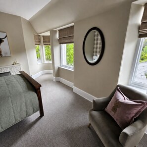 A bedroom with a bed, a chair, a window, and a mirror. - Fairytale Scots Baronial Coach House in Ballater, near Balmoral Castle (Ballater)