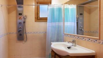 Ein Badezimmer mit Dusche, Waschbecken und Spiegel.