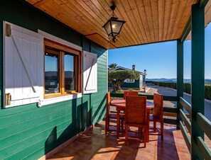 A covered outdoor seating area with a view of a road and distant hills. - Apartment 'Los Albares' with Mountain View, Wi-Fi and Air Conditioning (Las Canales)