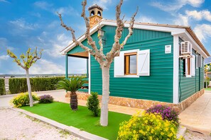 A small, single-story building with a green exterior and a white window.