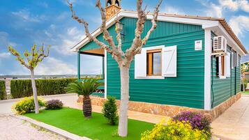 A small, single-story building with a green exterior and a white window.