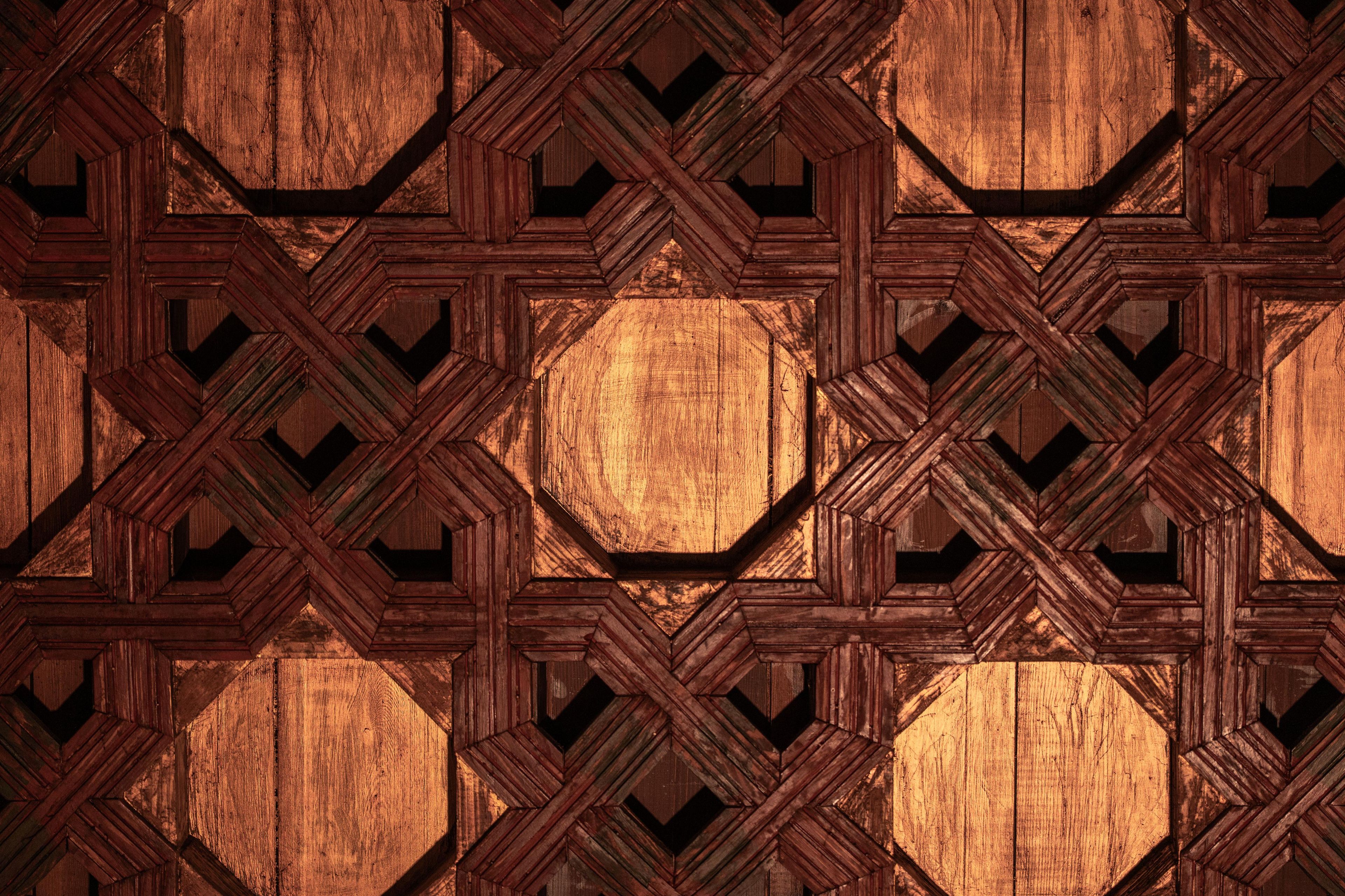 Un patrón geométrico de madera con formas entrelazadas y un hueco hexagonal central.