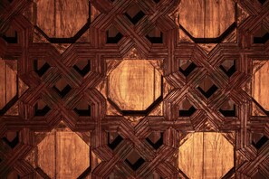 Un motif géométrique en bois composé de formes imbriquées et comportant un espace hexagonal central.