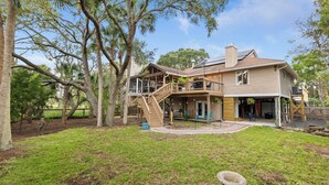 A two-story house with a covered porch, a staircase, and a deck. - Folly Fun House – Just Steps to the Beach (Folly Beach)